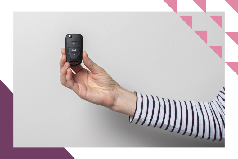 arm with a long-sleeved striped shirt holding wireless car key